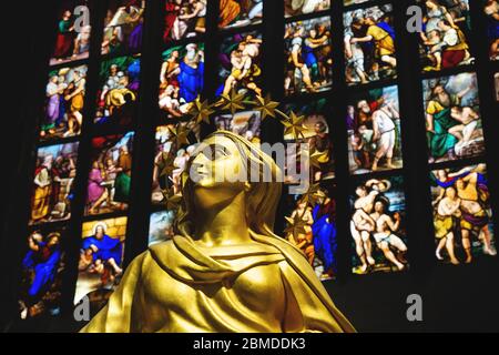 Mailand, Italien - 16. März 2017: Goldene Statue der heiligen Frau mit bunten Fensterkunst im Hintergrund im Mailänder Dom Stockfoto