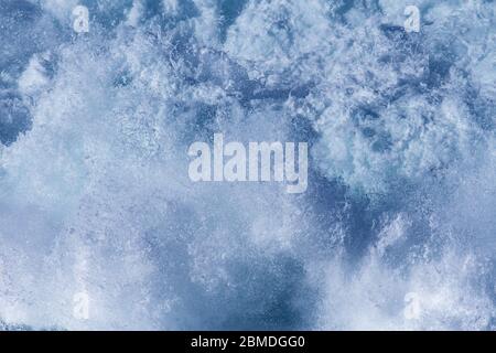 Aquatische Hintergrund der Meeresbrandung Wellen plätschern Nahaufnahme mit klarem, blauem Wasser und weißer Schaum Stockfoto