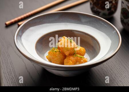 Japanisches chinesisches gebratenes Huhn oder Fisch Tempura auf einem blauen Keramikplatte und Essstäbchen Stockfoto