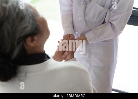 Der junge Hausarzt spricht mit Senioren Stockfoto