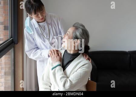 Der junge Hausarzt spricht mit Senioren Stockfoto