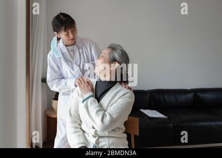 Der junge Hausarzt spricht mit Senioren Stockfoto