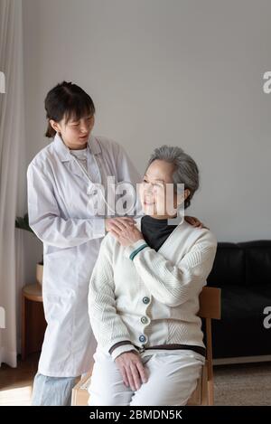 Der junge Hausarzt spricht mit Senioren Stockfoto