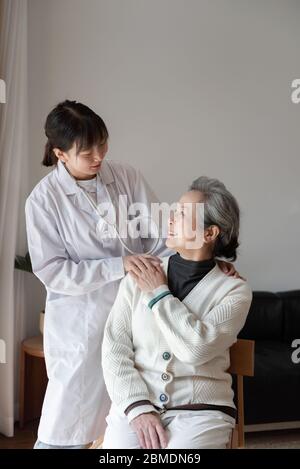 Der junge Hausarzt spricht mit Senioren Stockfoto