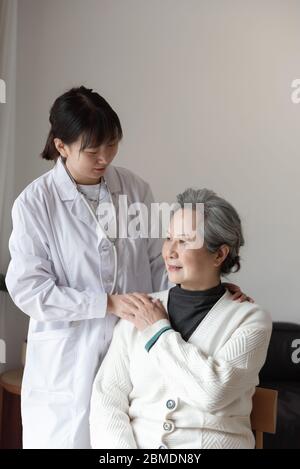 Der junge Hausarzt spricht mit Senioren Stockfoto