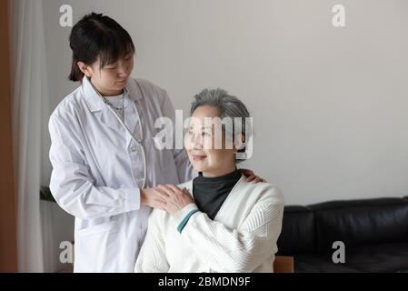 Der junge Hausarzt spricht mit Senioren Stockfoto