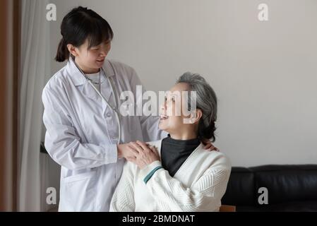 Der junge Hausarzt spricht mit Senioren Stockfoto