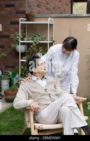 Der junge Hausarzt spricht mit Senioren Stockfoto