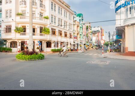 Can Tho Vietnam - Oktober 16 2013; City Street mit Kolonialstil Gebäude an der Ecke und Menschen in Bewegung am frühen Morgen begraben. Stockfoto