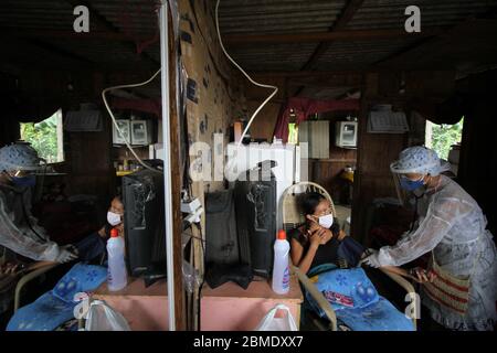 Parque Das Tribos, Brasilien. Mai 2020. Die einheimische Krankenschwester Vanda Ortega (r) besucht die Bewohner des 'Tribal Park', die von den Symptomen von Covid-19 berichtet haben. Die Region Manaus ist stark vom Coronavirus betroffen, mehr als 135,000 Covid-19-infizierte wurden landesweit bestätigt. Angesichts der grassierenden Pandemie haben Vertreter indigener Organisationen im Amazonasgebiet die internationale Gemeinschaft um finanzielle Unterstützung gebeten. Kredit: Lucas Silva/dpa/Alamy Live News Stockfoto