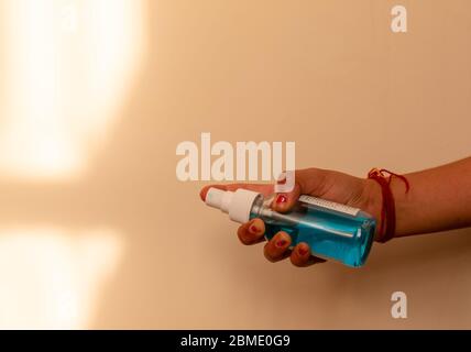 Ansicht des Mädchens, das Handdesinfektionsmittel auf buntem Hintergrund hält Stockfoto