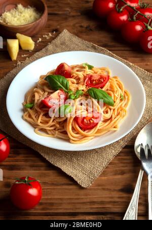 Spaghetti in Tomatensauce mit Käse auf braunem Hintergrund. Selektiver Fokus Stockfoto