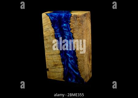 Gießen blauen Epoxidharz mit Natur burl Ahorn Holzwürfel auf schwarzem Hintergrund Stockfoto