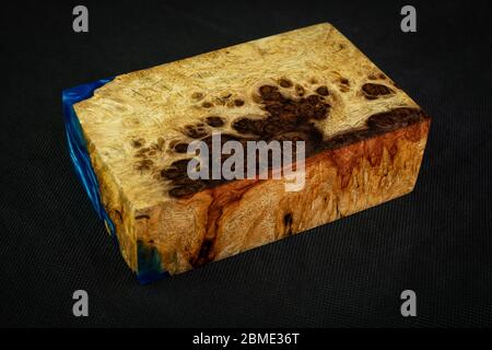 Gießen blauen Epoxidharz mit Natur burl Ahorn Holzwürfel auf schwarzem Hintergrund Stockfoto