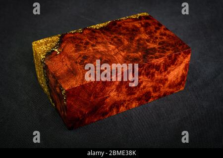 Gießerei Epoxidharz Gold mit Natur Burma PADAUK Holzwürfel auf schwarzem Hintergrund Stockfoto