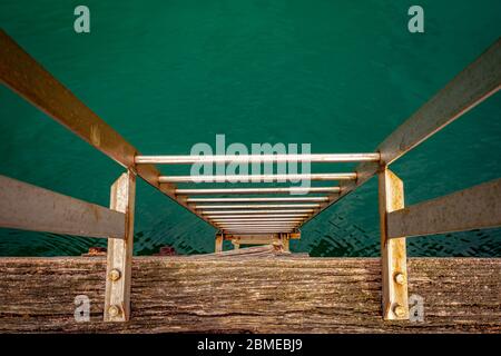 Blick von oben auf die Leiter auf der Pier Seite, die zum Wasser führt Stockfoto