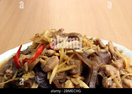 Hähnchenbrust mit Ingwer aus Pilzen, Knoblauch, frischen Paprika auf einem Teller und auf einem Holzhintergrund gelegt. Stockfoto