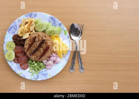 Draufsicht. Reis mit Garnelenpaste gemischt, bestehend aus süßem Schweinefleisch, chinesischer Wurst, Spiegeleier, Gurkenscheibe, saurer Mango, Schalotte, Yard Long Bohne, Roa Stockfoto