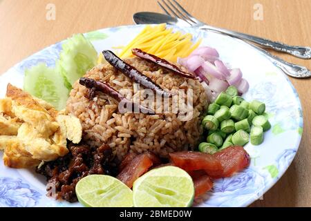 Reis mit Garnelenpaste gemischt, bestehend aus süßem Schweinefleisch, chinesischer Wurst, Spiegeleier, Gurkenscheibe, saurer Mango, Schalotte, Yard Long Bohne, gebratener peppe Stockfoto