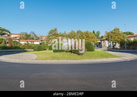 Verkehrskreisel in einem typisch italienischen Dorf. Calcinate del Pesce Stockfoto