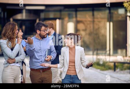 Lächelnder Geschäftsmann und Frau in der Pause, herumlaufen und reden Stockfoto