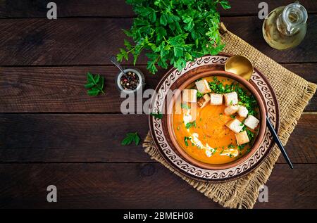 Kürbissuppe in einer Schüssel mit Croutons und Petersilie serviert. Vegane Diät Suppe. Vegetarisches Essen. Draufsicht, Overhead Stockfoto
