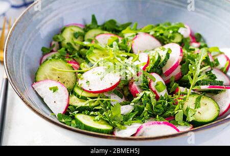 Vegetarischer Gemüsesalat aus Rettich, Gurken, Rucola und grünen Zwiebeln. Gesundes veganes Essen. Stockfoto