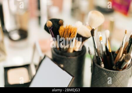 Nahaufnahme von professionellen Bürsten in verschiedenen Größen und Formen für Make-up auf dem Frauentisch Stockfoto