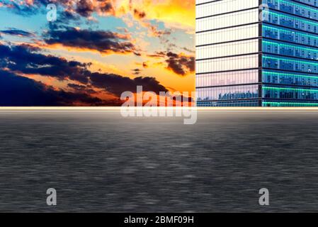 Leere Asphaltpflaster und moderne Stadtmarkanten in der untergehenden Sonne Stockfoto