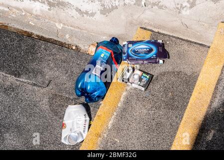 Sortiment von entsorgten Artikeln auf Schritten. Viagra, Zigarettenschachtel, Bierdose und Alkoholflasche. Während der COVID-19 Coronavirus-Sperrzeit. Außen Stockfoto