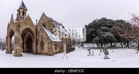 London, England, Großbritannien - 20. Januar 2013: Schnee fällt auf die gotische Kapelle und die Grabsteine des Lambeth Cemetery in Tooting, Süd-London. Stockfoto