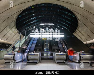 London, England, Großbritannien - 10. März 2020: Pendler fahren mit Rolltreppen an einem der Eingänge zur modernen Canary Wharf U-Bahnstation in Londons Docklands Stockfoto