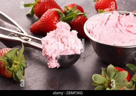 Erdbeer-Eiskugel mit frischen Erdbeeren auf rustikalem Hintergrund Stockfoto