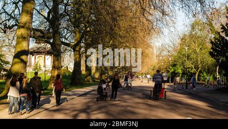 London, England, UK - 16. März 2014: Radfahrer fahren Fahrräder und Cargo trikes entlang der von Bäumen gesäumten Alleen des Battersea Park Schlitten fahren auf einem Sun Stockfoto