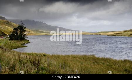 Niedrige Wolken umhüllen den alten Mann von Storr, der über Loch Fada auf der Isle of Skye landslip stapelt. Stockfoto