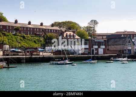 Weymouth, England, Großbritannien - 18. Mai 2013: Fußgänger laufen vorbei am Weymouth Sailing Club und den Lifeboat Station Gebäuden auf der Noth Parade neben Weymouth Harbo Stockfoto