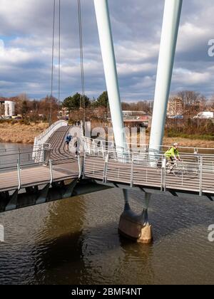 Lancaster, England, Großbritannien - 2. April 2013: Radfahrer überqueren den Fluss Lune auf Lancaster's Millennium Bridge Fuß und Radweg, Teil des National Cycle Netwo Stockfoto