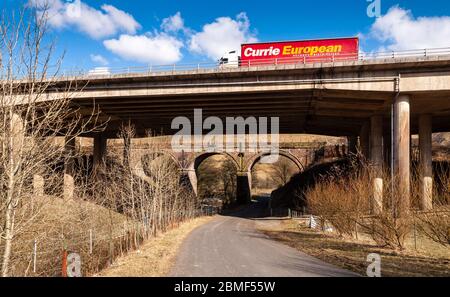 Tebay, England, Großbritannien - 30. März 2013: Viadukte führen die Autobahn M6 und die West Coast Mainline Eisenbahn über den Borrow Beck in der Lune Gorge in Cumbria. Stockfoto