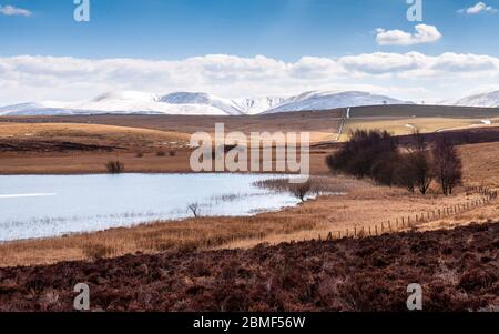 Die schneebedeckten Howgill Fells des Yorkshire Dales National Park bilden die Kulisse für die Sunbiggin Moors und den Sunbiggin Tarn Lake in Cumbria, E Stockfoto