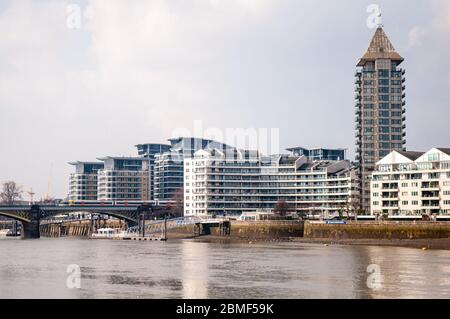 London, England, Großbritannien - 28. März 2013: Ein Londoner Overground-Pendlerzug überquert die Themse neben den neu erbauten Wohngebäuden von Imperial Stockfoto