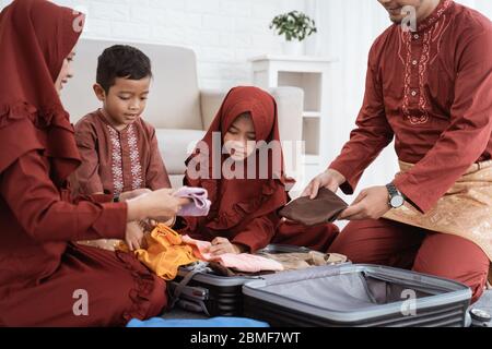 Asiatische Familie bereiten Kleidung und legte in einem Koffer, um Mudik in die Heimatstadt gebracht werden Stockfoto