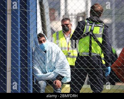 Ein Mann, der als Migranten gilt, wird von Grenztruppen-Offizieren verarbeitet, nachdem er nach kleinen Bootsvorfällen im Kanal heute Morgen in Dover, Kent, an Land gebracht wurde. Stockfoto