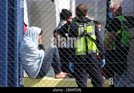 Ein Mann, der als Migranten gilt, wird von Grenztruppen-Offizieren verarbeitet, nachdem er nach kleinen Bootsvorfällen im Kanal heute Morgen in Dover, Kent, an Land gebracht wurde. Stockfoto