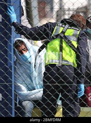 Ein Mann, der als Migranten gilt, wird von Grenztruppen-Offizieren verarbeitet, nachdem er nach kleinen Bootsvorfällen im Kanal heute Morgen in Dover, Kent, an Land gebracht wurde. Stockfoto