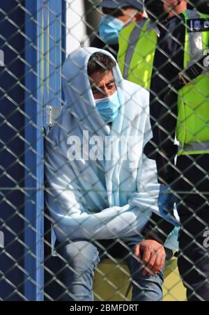 Ein Mann, der als Migranten gilt, wird von Grenztruppen-Offizieren verarbeitet, nachdem er nach kleinen Bootsvorfällen im Kanal heute Morgen in Dover, Kent, an Land gebracht wurde. Stockfoto