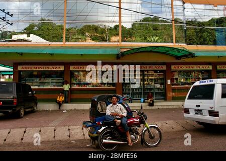 Ein Auto-Rikscha (lokal bekannt als "bentor") Fahrer und die Einheimischen vor dem beliebten Aido Mini Plaza in Sibolga City, Nord-Sumatra, Indonesien. Archivfoto. Stockfoto