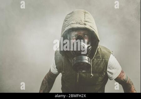 Mann in Gasmaske umgeben von Rauch Stockfoto