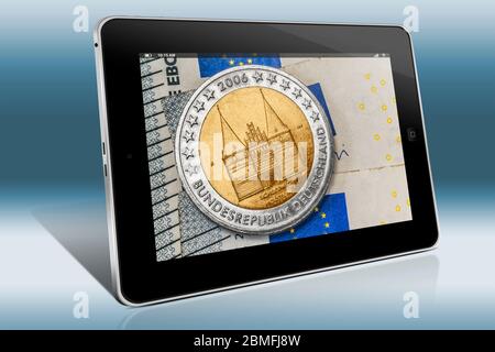 Eine 2-Euro-Gedenkmünze aus Deutschland mit dem Holsten Gate Lübeck auf Euro-Banknoten, Blick auf einen Tablet-PC Stockfoto