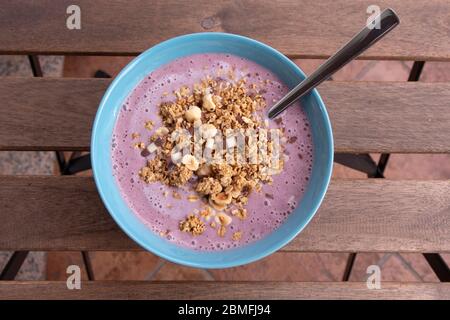 Gesundes Frühstück, hausgemachte Erdbeere, Heidelbeere, Banane und Joghurt Smoothie mit knusprigen Müsli und Haferflocken Stockfoto
