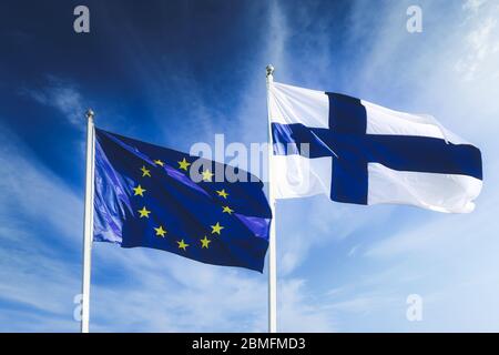 Flaggen der EU und Finnlands am Europatag am 9. Mai 2020 vor blauem Himmel.